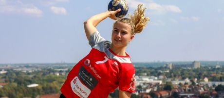 Junge Frau wirft aus dem Sprung heraus einen Handball | Sparkasse Hannover