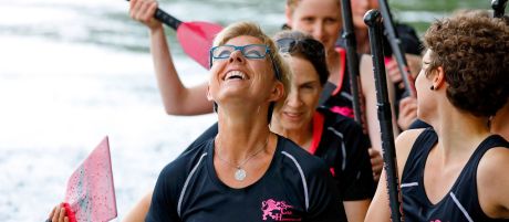 Frauen sitzen im Drachenboot und lachen gemeinsam| Sparkasse Hannover