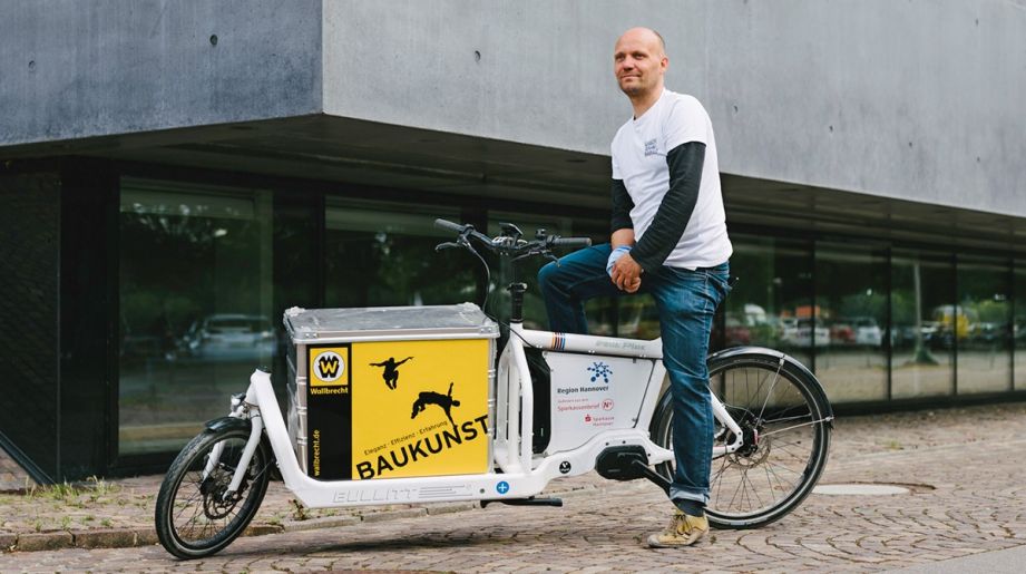 Mann posiert auf einem Lastenrad | Sparkasse Hannover