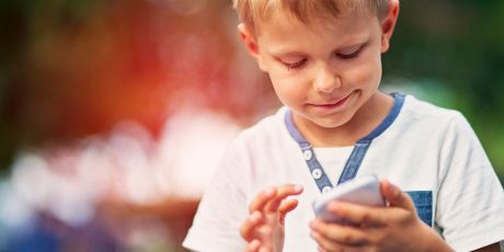 Kleiner Junge schaut auf ein Smartphone  | Sparkasse Hannover