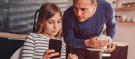 Junge Leute: Vater schaut mit seiner Tochter auf ein Smartphone | Sparkasse Hannover
