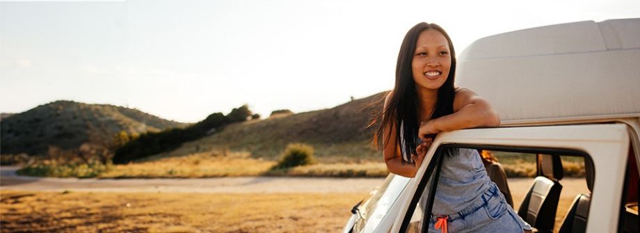 Junge Leute: Studenten - Junge Frau steht in der Tür eines Autos und lacht | Sparkasse Hannover