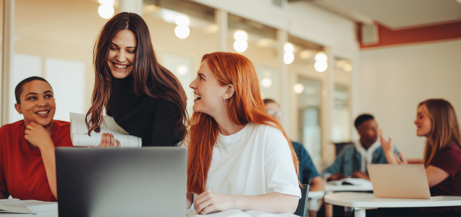 Junge Leute: Drei Frauen sitzen lächelnd vor einem Laptop | Sparkasse Hannover