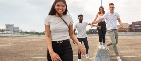 Vier junge Menschen laufen lachend über ein Parkdeck | Sparkasse Hannover