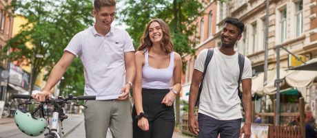 Drei junge Menschen gehen lachend eine Straße entlang | Sparkasse Hannover