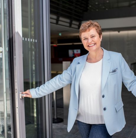 Mitarbeiterin einer Sparkasse Filiale steht lächelnd in der Tür | Sparkasse Hannover