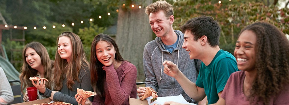Eine Gruppe Teenager sitzt beisammen und lacht herzhaft | Sparkasse Hannover
